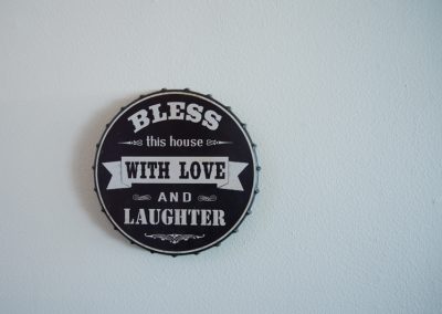 Wall decoration saying "bless this house with love and laughter"