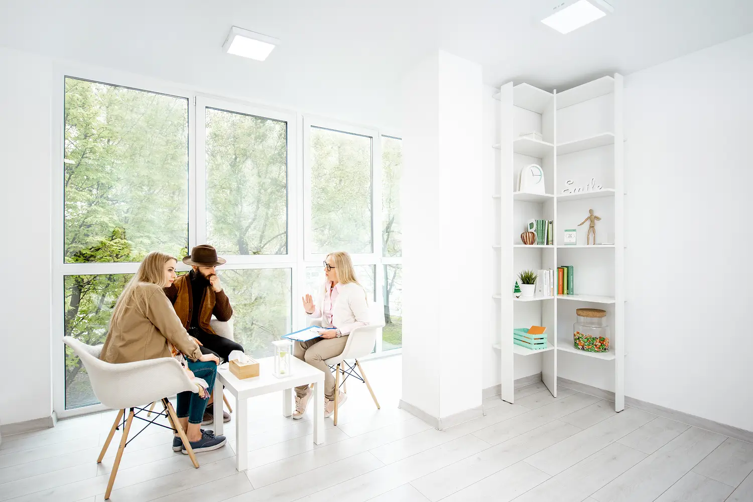 a group of people sitting at a table in a room with windows